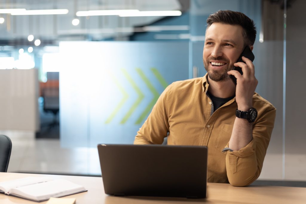 Man smiling on the phone while at the office