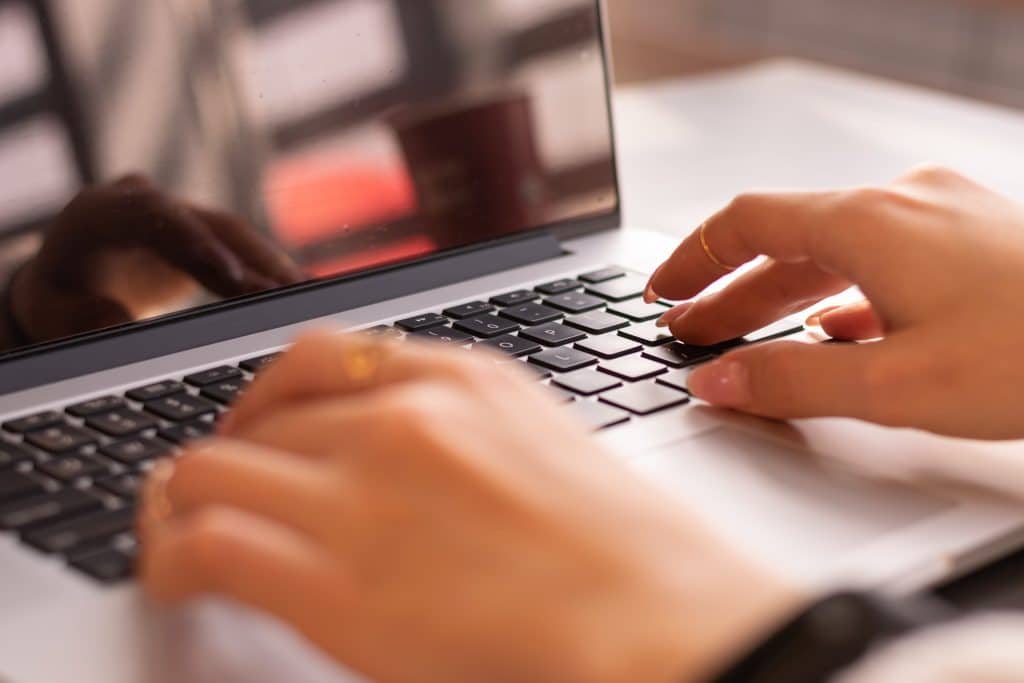 Person typing on a Mac laptop