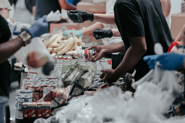 A charity organization handing out fresh, canned, and packaged food to the community.