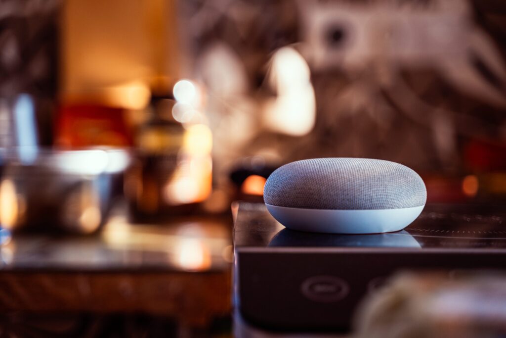 A smart AI speaker is in the foreground with a blurred background.
