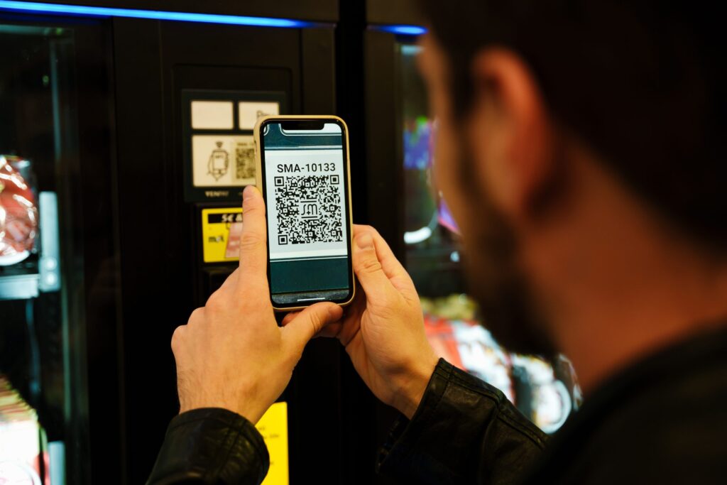 Young bearded man scanning qr code while standing in subway