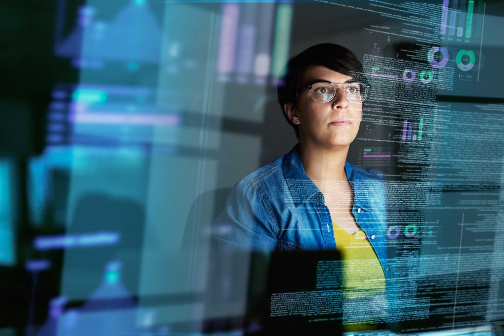 Professional looking woman working on a computer with code snippets surrounding her